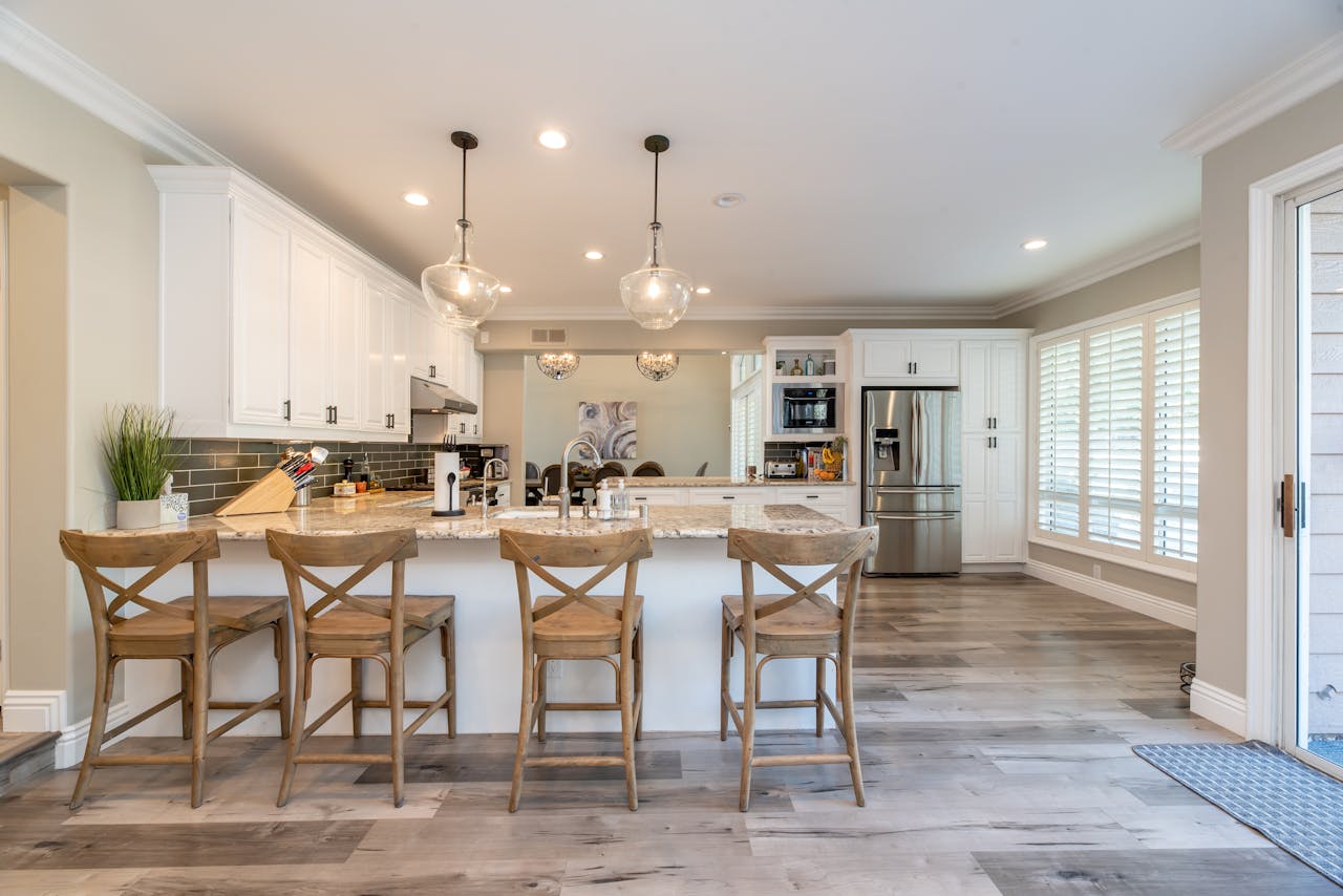 Services Bright and spacious kitchen interior featuring bar stools and modern design elements.
